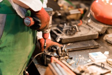 Mechanic Assembling a Machinery Component in a Workshop. clipart