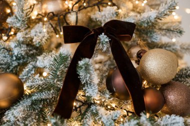 Altın süslemeli ve kadife fiyonklu zarif Noel ağacı süslemesi..