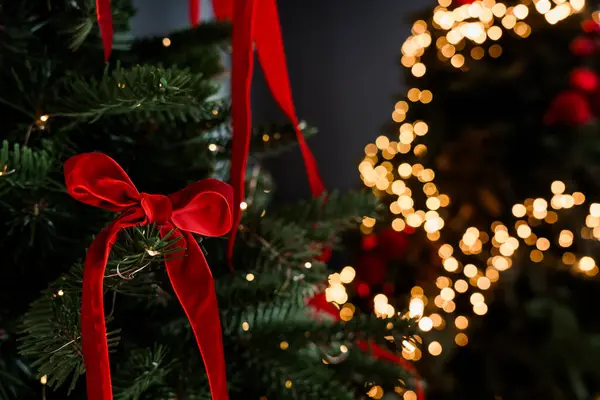 Kırmızı Kurdele ve Sıcak Bokeh Işıklı Şenlikli Noel Ağacı.