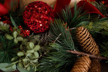 Kırmızı süs ve kozalaklı Noel Süslemesi.