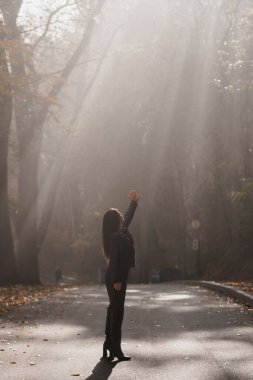 Ethereal Encounter: A Woman Reaching for Light in a Misty Forest Path. clipart