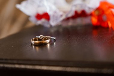 Karanlık Ahşap bir zemin üzerinde zarif alyanslar ve arka planda narin bir dekor..