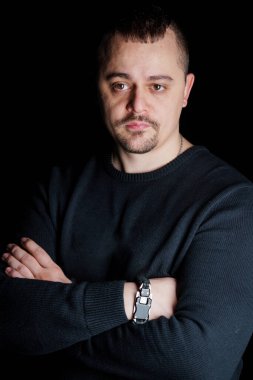 Siyah Arkaplan Karşısında Siyah Süveterli Düşünceli Bir Adamın Portresi.