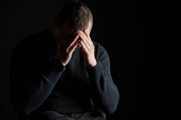 Эмоциональная борьба: человек в созерцании на тёмном фоне.