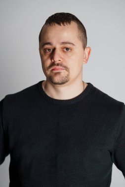 Tarafsız Arkaplan Karşısında Sıradan Siyah Kazaklı Ciddi Bir Adamın Portresi.