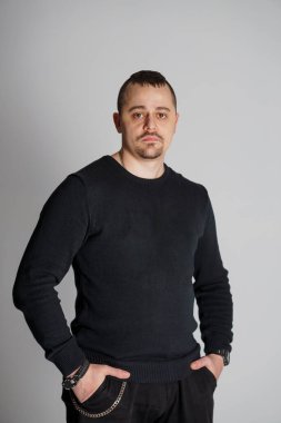 Siyah Süveterli Güvenilir Adam Tarafsız Arkaplan Karşısında Pozisyon.