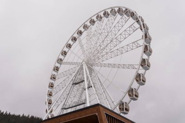 Kasvetli bir gökyüzüne karşı dev dönme dolap..