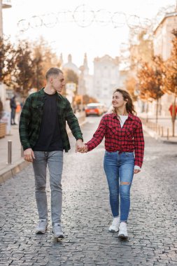 Günbatımında Büyüleyici Şehir Caddesinde Romantik Yürüyüşün keyfini çıkaran Genç Çift.