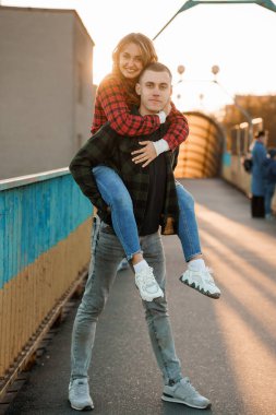 Gün batımında Köprüde Aşkı kucaklayan Neşeli Çift.