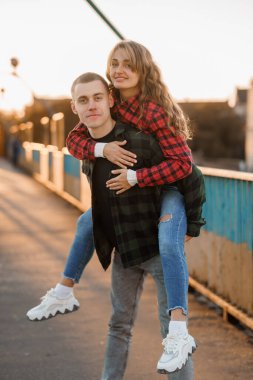 Sevgi dolu çift, gün batımının aydınlık köprüsünde neşeli bir anı paylaşıyor..