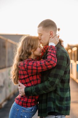 Gün batımında Kucaklayan Sevgi dolu bir çift Damalı Kalıpta.