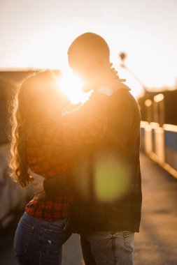 Siluetli Şekiller ve Yumuşak Işıklı Genç Bir Çiftin Romantik Günbatımı Kucaklaşması.