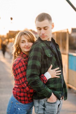 Gün batımında rahat Flannel gömleklerle kucaklaşan romantik çift.