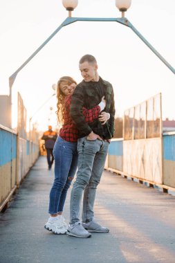 Romantik Çift Gün Batımında Köprüde Kucaklaşıyor.