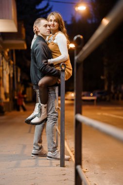 Romantik Akşam Yürüyüşü: Şehir Büyüsüne Kucaklayan Bir Çift.