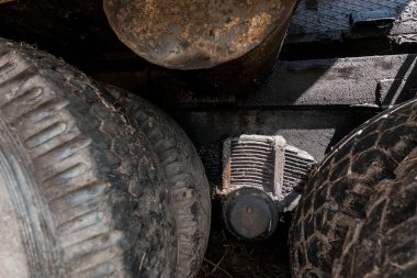 Rusty Tires and Engine Parts Obscured Underneath a Vehicle. clipart