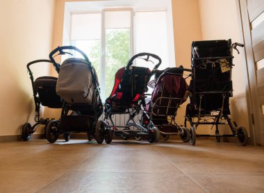 A Row of Various Baby Strollers in a Bright Room. clipart