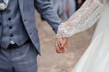 Yeni evlilerin düğün törenlerinde el ele tutuşmalarının romantik bir anı..