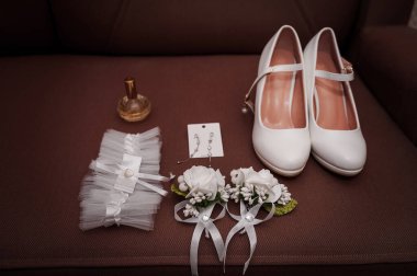 Kahverengi bir koltukta gösterilen zarif düğün aksesuarları.