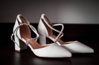 Koyu Yüzeyde Gümüş Kayışlı Zarif Beyaz Topuklar.