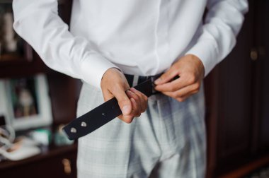Damat, Düğün Töreni İçin Giyinirken Kemerini Ayarlıyor.
