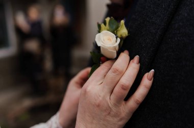 Intimate Moment Captured with a Rose Boutonniere and Elegant Hand Gesture. clipart