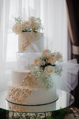 Üç Kademe Şık Düğün Pastası Güller ve Hassas Altın Aksanlarla süslenmiş.
