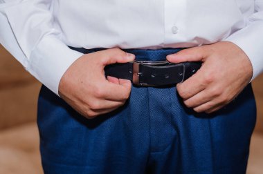 Zarif Resmi Kıyafet: Kemerini Ayarlayan Bir Adam Üzerine Odaklanma.