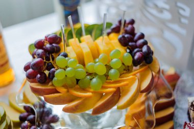 Üzüm ve Elmalar da dahil olmak üzere çeşitli taze meyvelerle dolu canlı meyve tabağı.