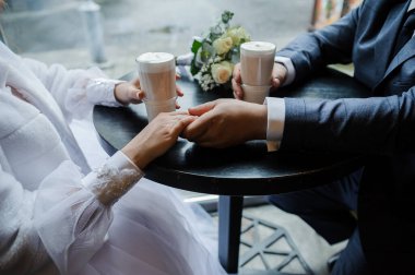 Romantik an: Düğün Çifti Kahve İçerken El ele tutuşuyor.