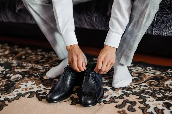 Resmi Giyimli Bir Adam Siyah Elbisesini Şık Bir Halıya Bağlıyor.