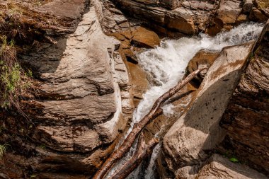 Serene Rocky Stream Flowing Through Nature's Crevices. clipart