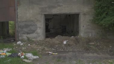 Yıkılan duvarlar ve aşırı büyüyen enkazlarla terk edilmiş bir depo.