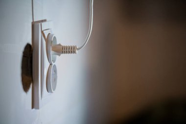 Tarafsız Duvar Arkaplanına iliştirilmiş Fişi olan Beyaz Elektriksel Çıkış 'ın Yakın Çekimi.