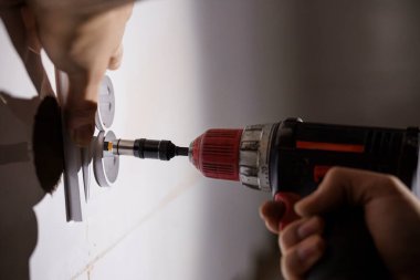 Elektrikçi kablosuz matkapla elektrik prizi kuruyor.