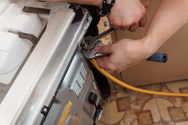 Aletler ve Odaklanmış Ellerle Gaz Fırınının Profesyonel Tamiri.