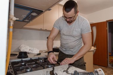 Modern bir mutfağa gaz ocağı kuran becerikli bir tamirci..