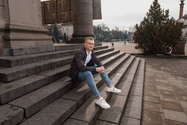 Şehir Parkı 'nda Taş Merdivenlerde Oturan Genç Adam.