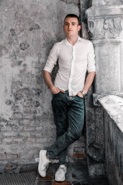 Sıradan Zarafet: Klasik Taş Duvara Karşı Poz Veren Genç Bir Adam.