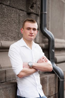 Duvara yaslanan Kendine Güvenen Genç Adam.