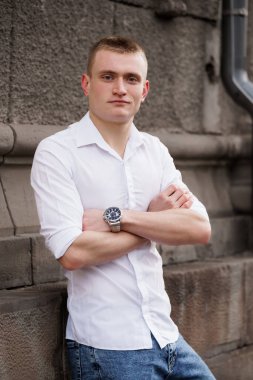 Taş Duvara Karşı Sıradan Giyinen Kendine Güvenen Genç Adam.