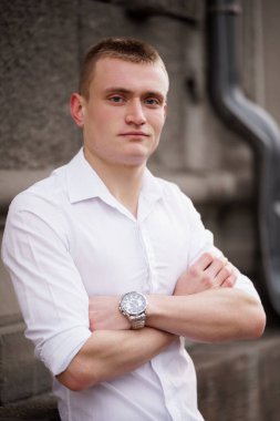 Şehir Arkaplanına Karşı Sıradan Beyaz Gömlekli Güvenilir Genç Adam.