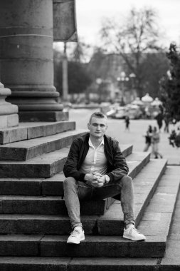 Şık Genç Adam Şehir Ayarlarında Taş Basamaklarda Poz Veriyor.