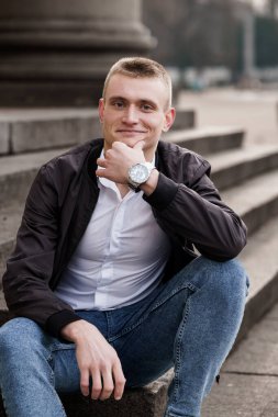 Genç Adam Şehir Ayarlarındaki Basamaklar Üzerine Düşünceli Poz Veriyor.