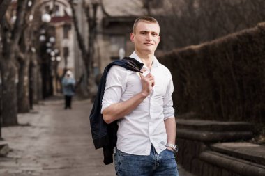 Şehirdeki Kendine Güvenen Genç Adam Omzunun Üzerindeki Ceketle Ayarlanıyor.