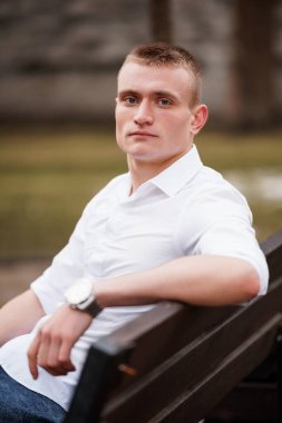 Park ortamında kendinden emin bir gencin portresi..