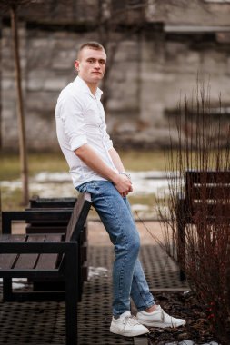 Sıradan bir genç adam parkta bir banka yaslanıyor..