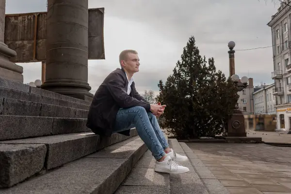 Düşünceli Gençlik Şehir Ayarlarında Basamaklarda Oturuyor.