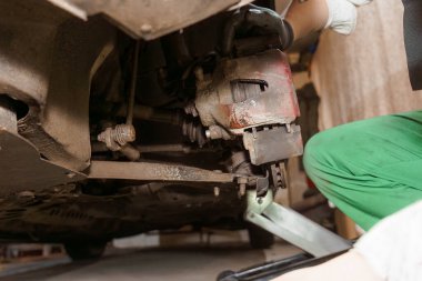 Garajda Araba Altında Fren Bakımı Yapan Tamirci.