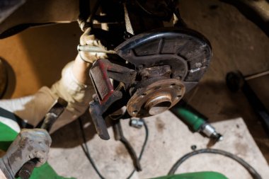 Otomotiv teknisyeni garajda fren montajı üzerinde çalışıyor.